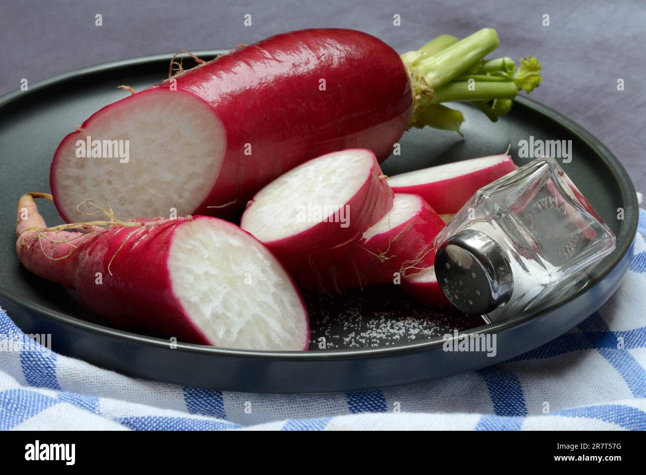 Roter Rettich, in Scheiben geschnitten, mit Salzfass, Lebensmittelfotografie Stockfoto