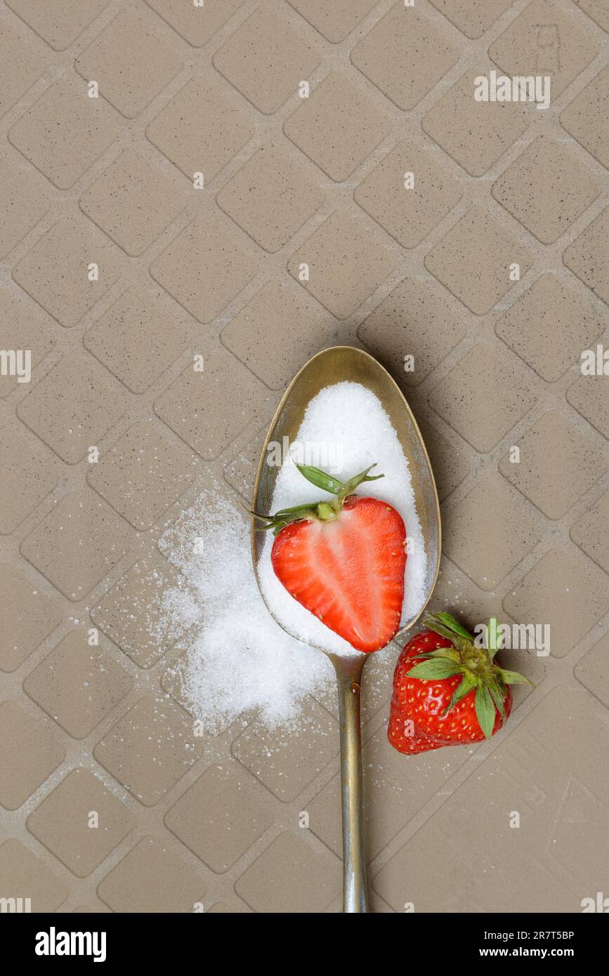 Löffel mit Zucker und Erdbeeren Stockfoto