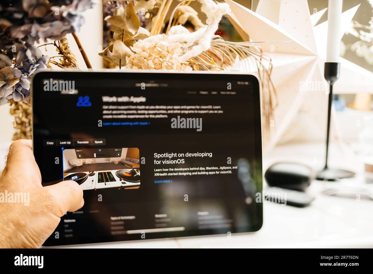 Paris, Frankreich – 6. Juni 2023: Entwicklung von Apps für Vision OS im Fokus – ein Mann, der auf iApd über das Mixed Reality XR Headset von Apple Vision Pro liest. Preis Stockfoto