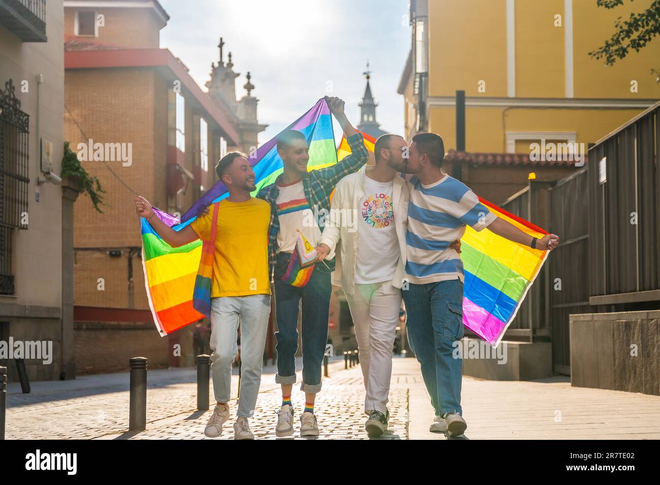 Lebensstil der umarmten homosexuellen Freunde, die auf der Schwulenprima-Party in der Stadt spazieren, Vielfalt junger Menschen, Demonstration mit den Regenbogenflaggen Stockfoto