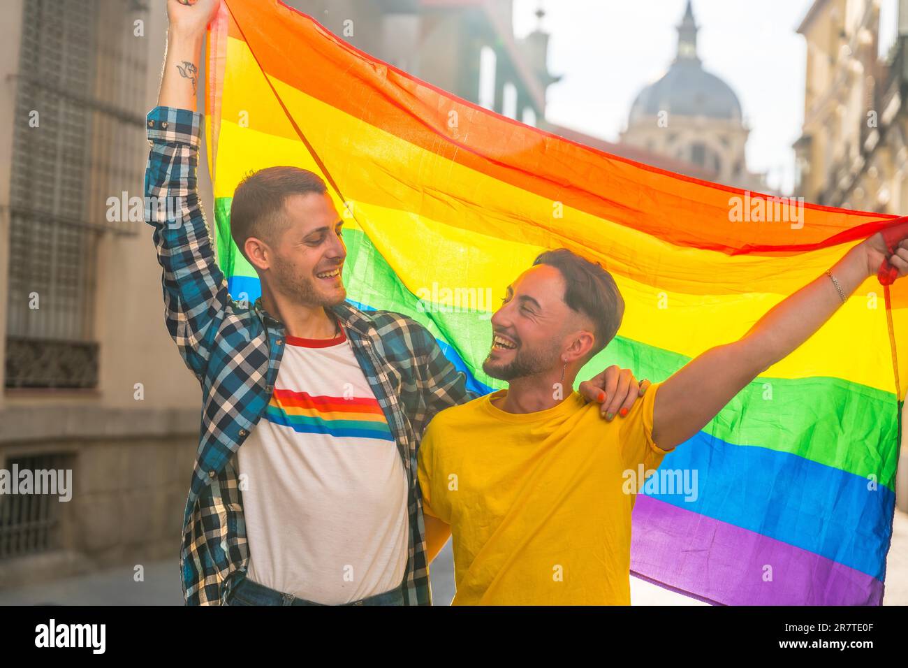 Porträt eines schwulen männlichen Paares mit Regenbogenflagge auf der Pride Party in der Stadt, lgbt Concept Stockfoto