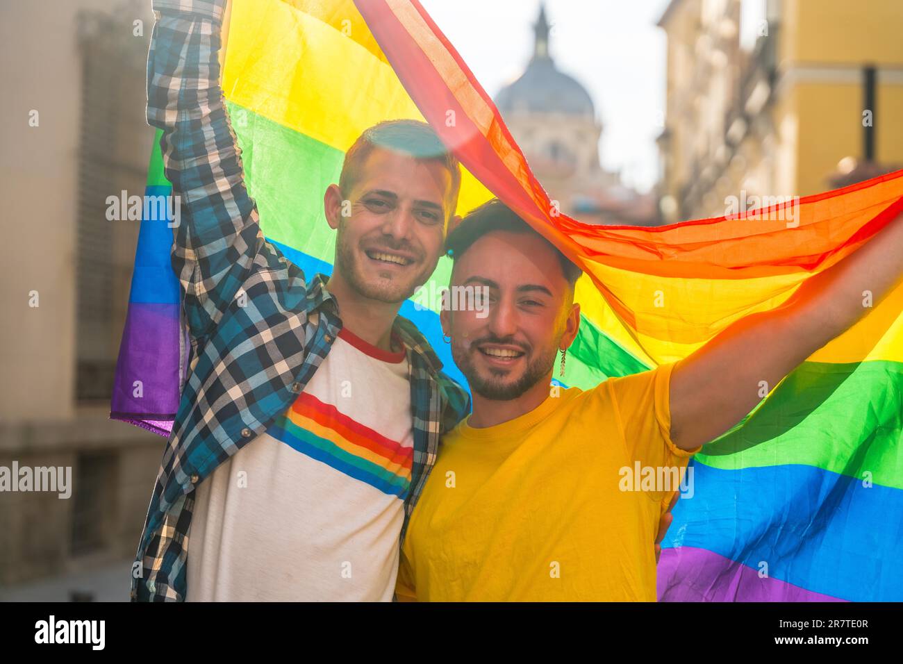 Porträt eines schwulen männlichen Paares mit Regenbogenflagge auf der Pride Party in der Stadt, lgbt Concept Stockfoto