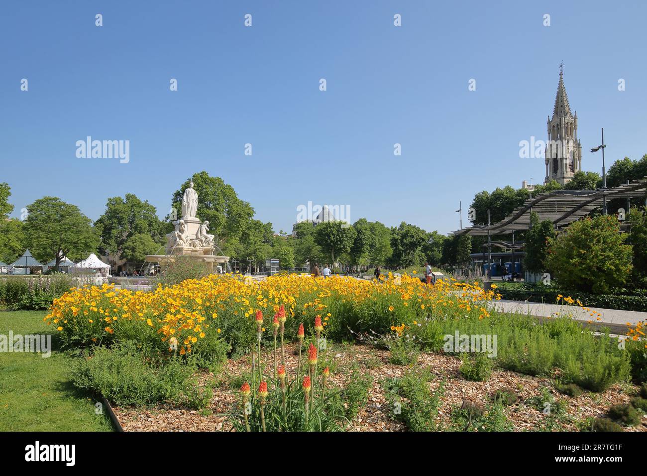 Fontaine Pradier mit Figur, Zierbrunnen, Garten, Blumen, Kirchturm, Esplanade Charles-de-Gaulle, Nimes, Gard, Provence, Frankreich Stockfoto