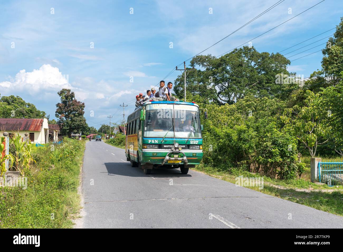 Transport von jungen Studenten, einige sitzen auf dem Busdach, gesehen auf der Insel Samosir in der Provinz Nord-Sumatra Stockfoto