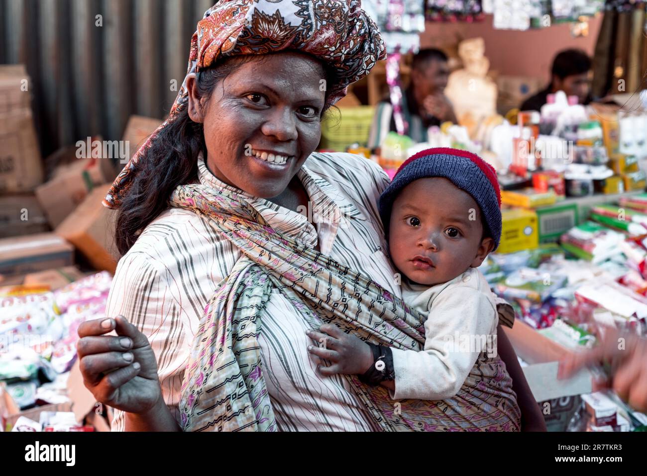 Toba Batak Frau mit Baby in traditioneller Kleidung auf dem Wochenmarkt von Panguran, der wichtigsten Stadt der Toba auf der Insel Samosir auf Sumatra Stockfoto