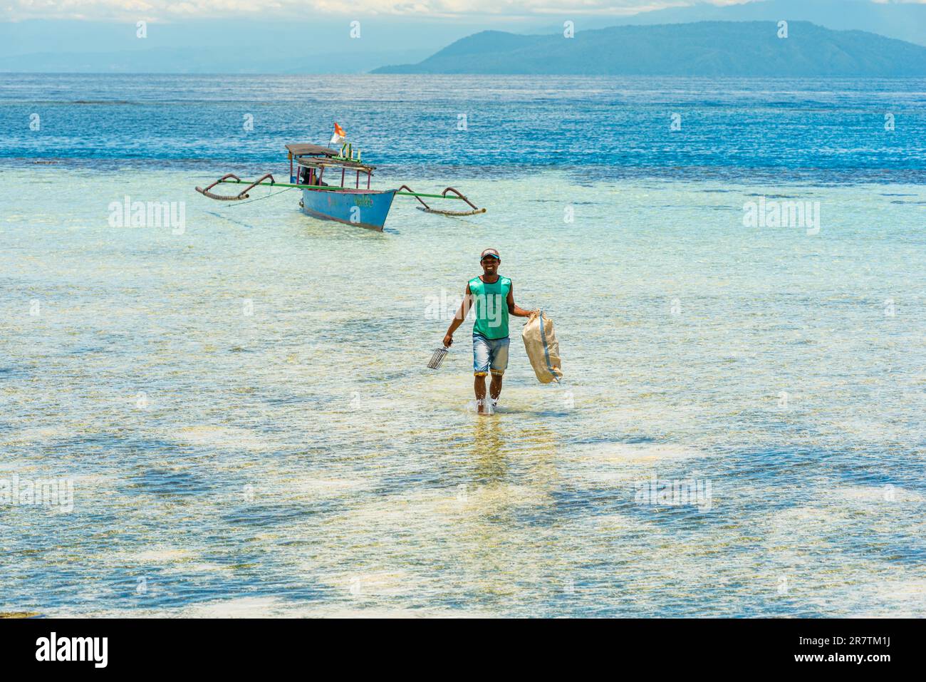 Outrigger-Boot am Strand der Insel Taupan in Sulawesi. Die Insel ist von einem Riff umgeben und bietet paradisiakale Bedingungen zum Tauchen und Stockfoto