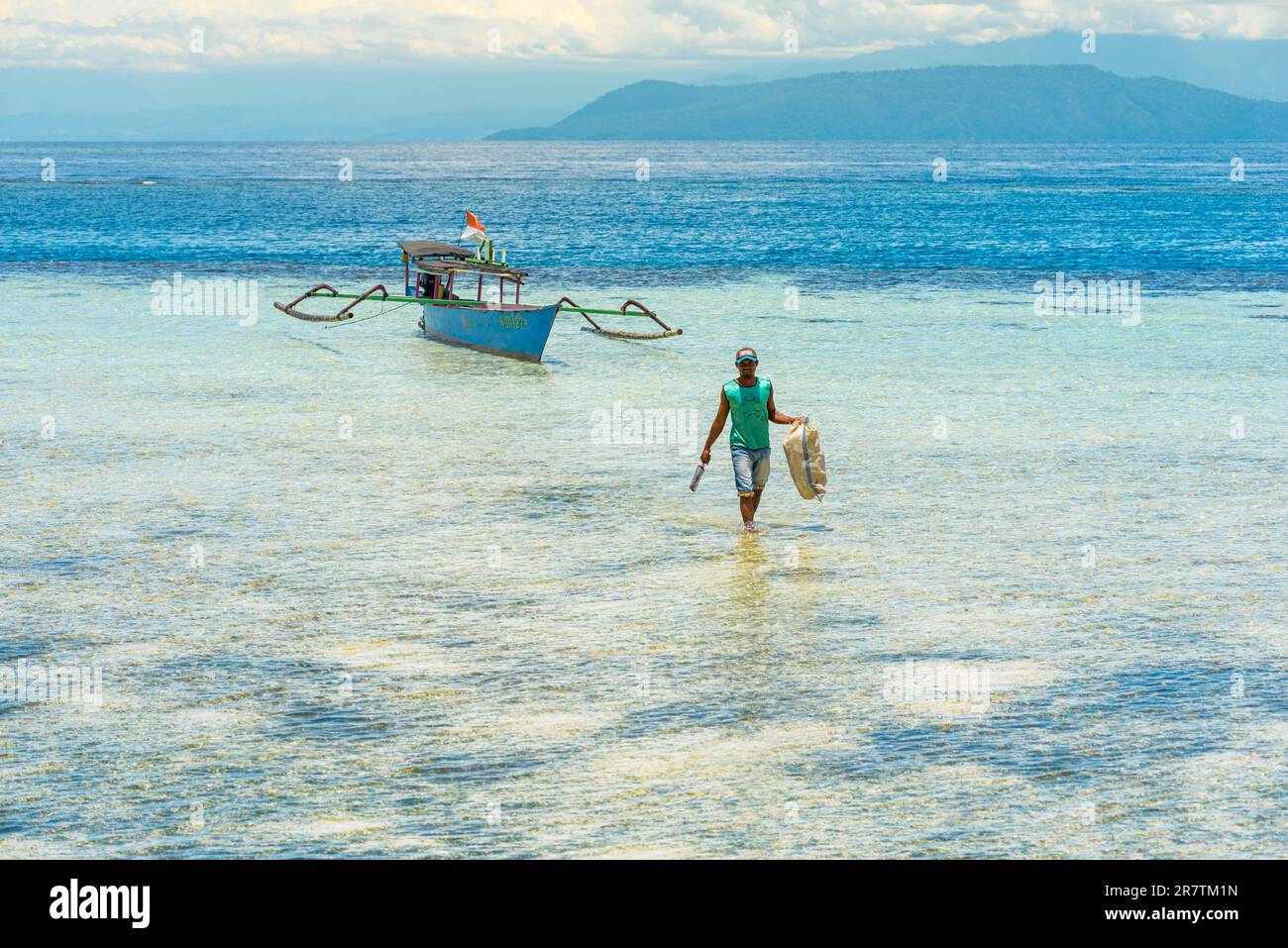Outrigger-Boot am Strand der Insel Taupan in Sulawesi. Die Insel ist von einem Riff umgeben und bietet paradisiakale Bedingungen zum Tauchen und Stockfoto