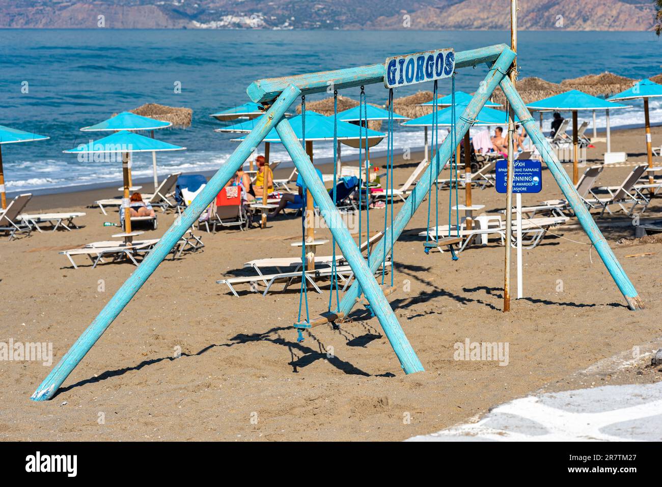 Spielplatz am Strand von Kalamaki. Eine Holzschaukel am Strand. Das Dorf am Ende der Messara-Ebene ist ein beliebtes Touristenresort im Stockfoto