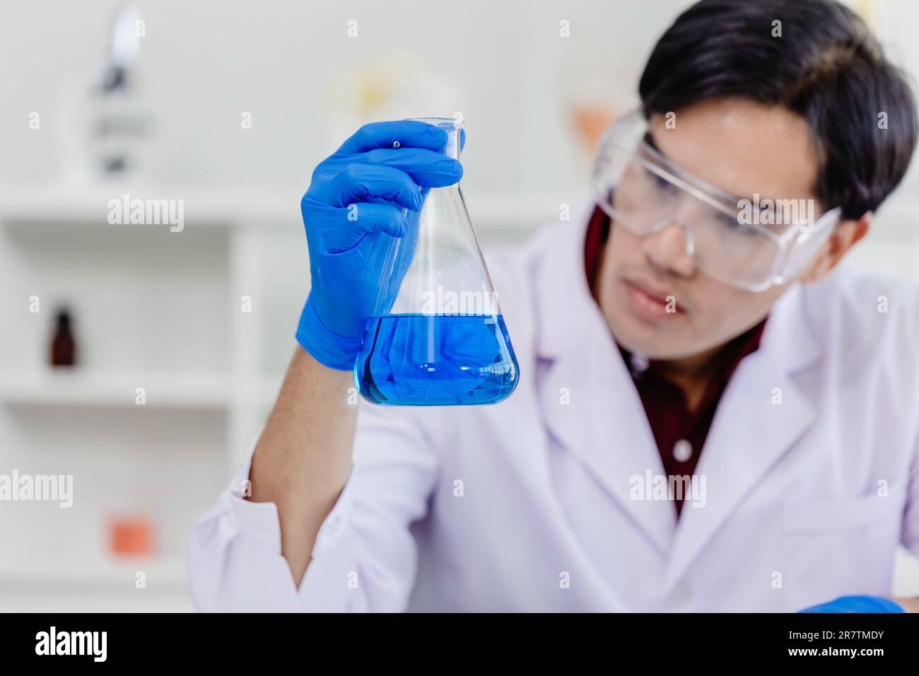 Junger asiatischer Wissenschaftler Mann trägt weiße Laboruniform Testen medizinische Formel im Labor Stockfoto
