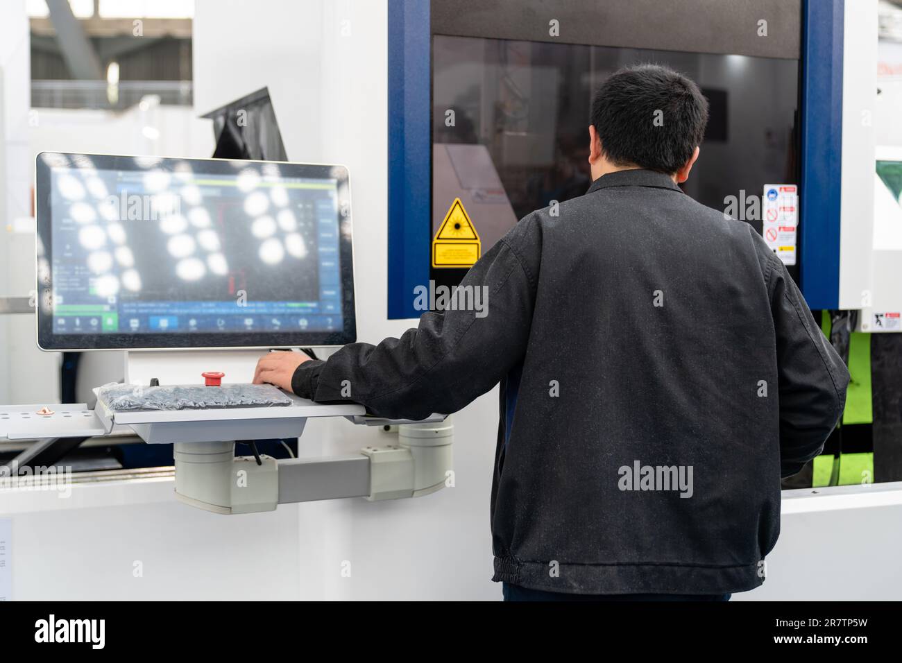 Der Arbeiter steuert automatische Werkzeugmaschinen in einer intelligenten Fabrik. Stockfoto