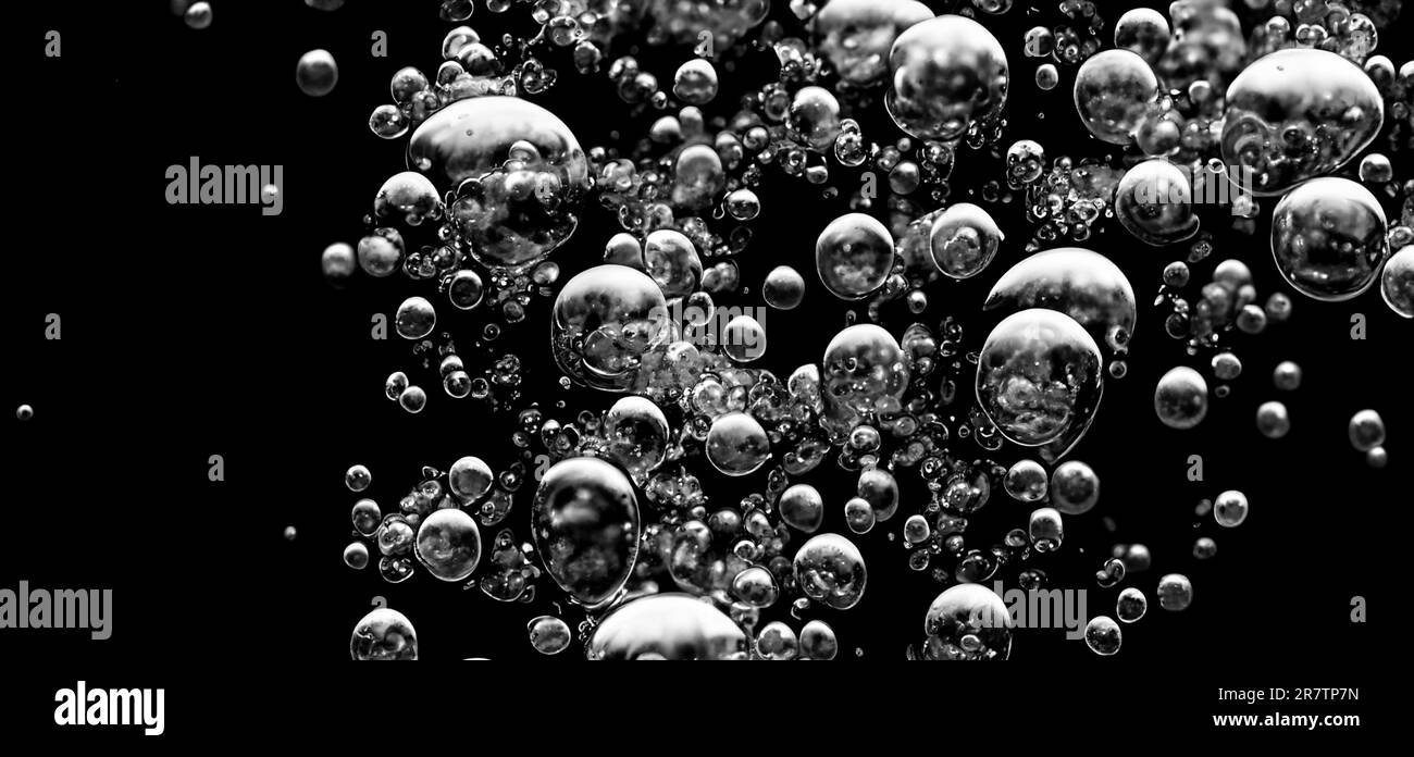 Soda-Wasserblasen, die unter Wasser vor schwarzem Hintergrund spritzen. Flüssige Cola-Textur, die wie eine Explosion in Ununde an die Oberfläche schwebt Stockfoto