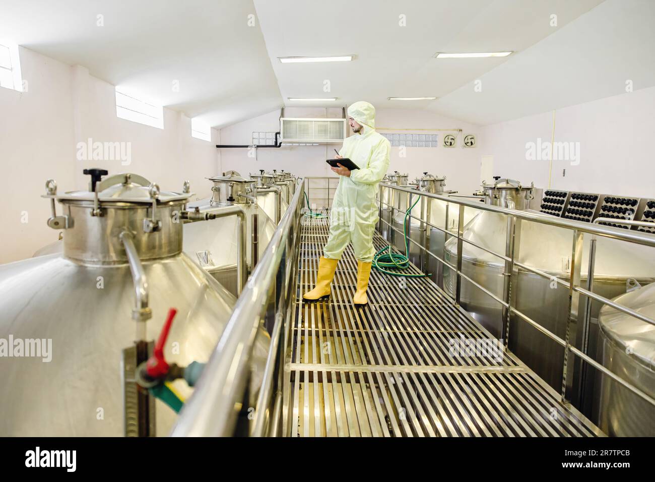 Brauerei Getränkefabrik Arbeiter prüfen Fermentationsbehälter mit sauberem und hygienischem Anzug. Stockfoto