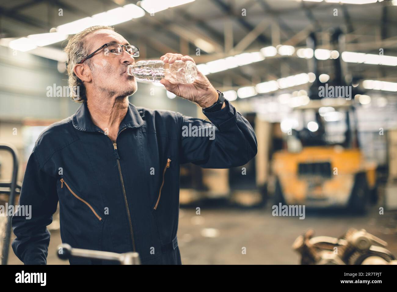 Durstiger leitender Angestellter, der Wasser trinkt und sich von müder, harter Arbeit an heißen Arbeitsplätzen erfrischt Stockfoto