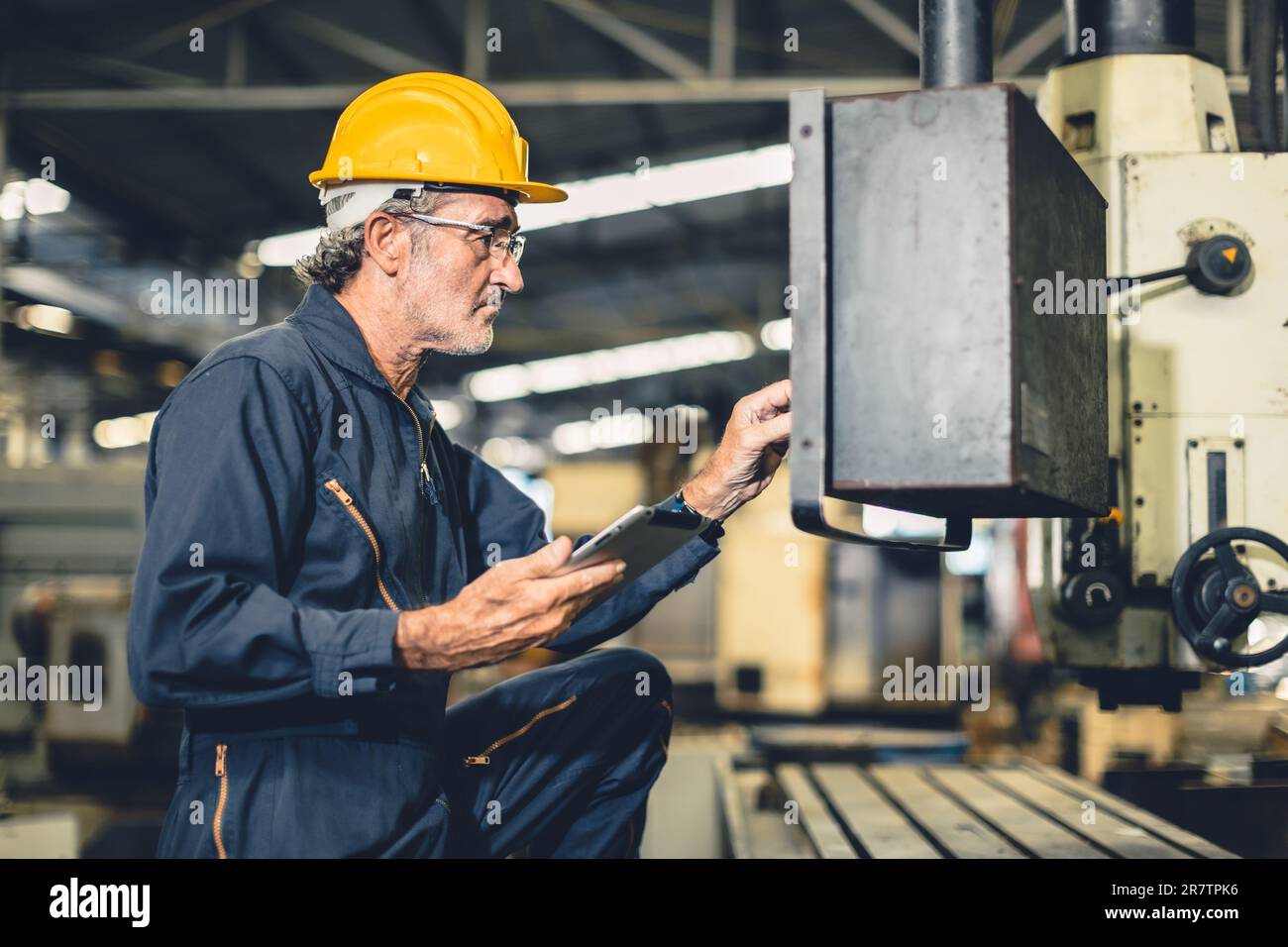 Erfahrene Ingenieure mit hohen Kenntnissen bedienen die CNC-Drehmaschine in der Automatisierungsanlage. Stockfoto