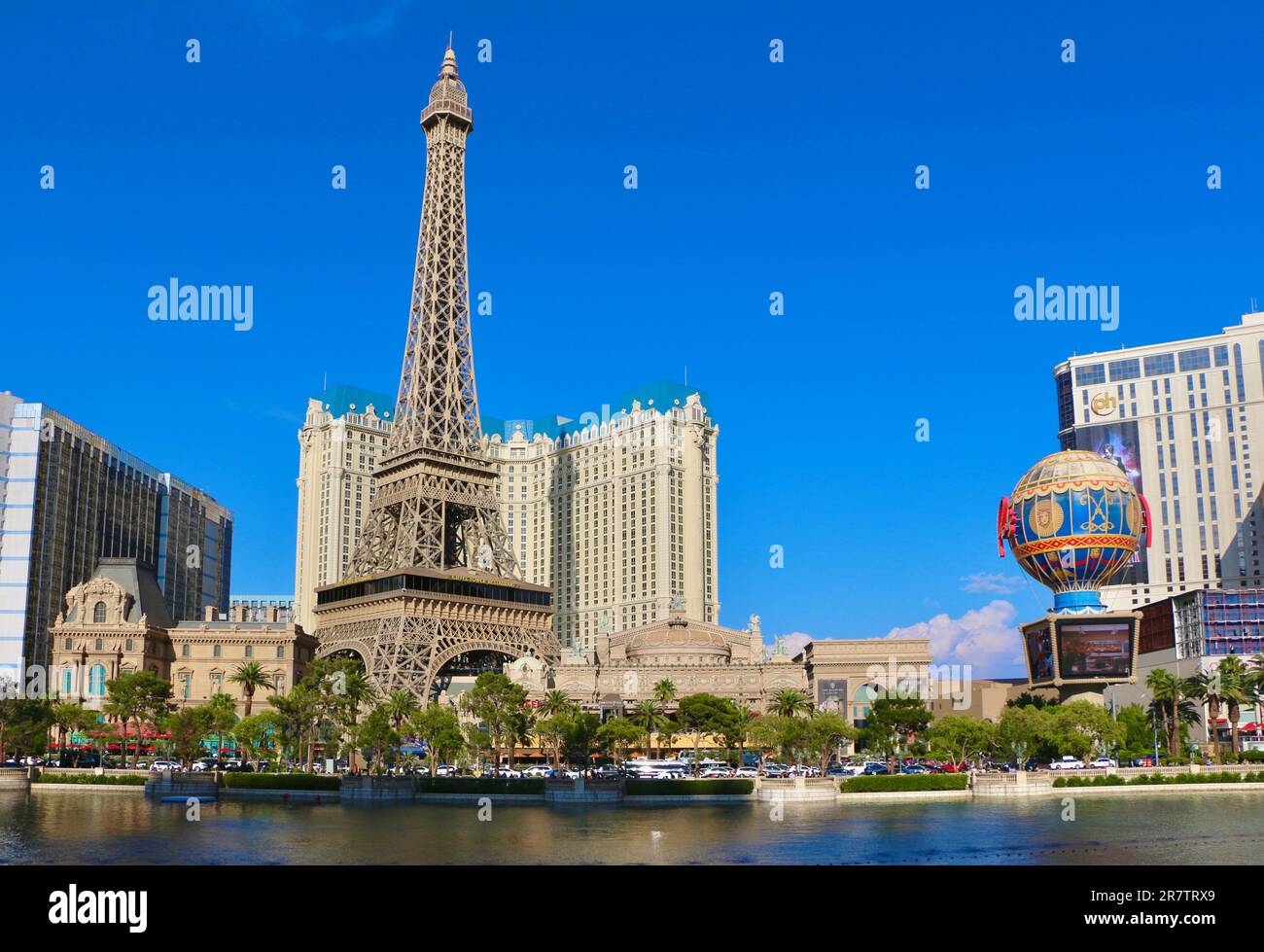 Das Bellagio Resort Brunnen während einer Ausstellung mit dem falschen halbmaßstäblichen Eiffelturm im Pariser Casino und Resort in der Nachmittagssonne Las Vegas Nevada USA Stockfoto