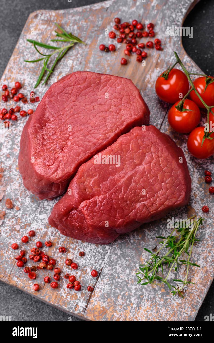 Rohes Rindfleisch-Eye-Steak mit Salz, Gewürzen und Kräutern, zubereitet ...