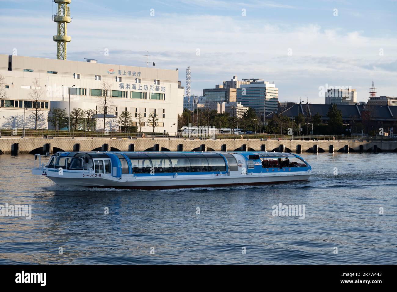 Yokohama, Präfektur Kanagawa, Japan. 23. Februar 2023. Eine Fähre, die an der Yokohama-Station und dem Ausbildungszentrum der japanischen Küstenwache vorbeifährt. Die japanische Küstenwache, die auf åº Japanisch als KaijÅ Hoan-chÅ (æµ·ä¸Šä¿å® ß) bekannt ist, ist für die Sicherheit und Gefahrenabwehr im Seeverkehr, die Bekämpfung der Meeresverschmutzung sowie Such- und Rettungseinsätze in japanischen Gewässern zuständig. Die Agentur musste sich historisch Herausforderungen aus Nordkorea und der Kommunistischen Partei Chinas stellen. (Kreditbild: © Taidgh Barron/ZUMA Press Wire) NUR REDAKTIONELLE VERWENDUNG! Nicht für den kommerziellen GEBRAUCH! Stockfoto