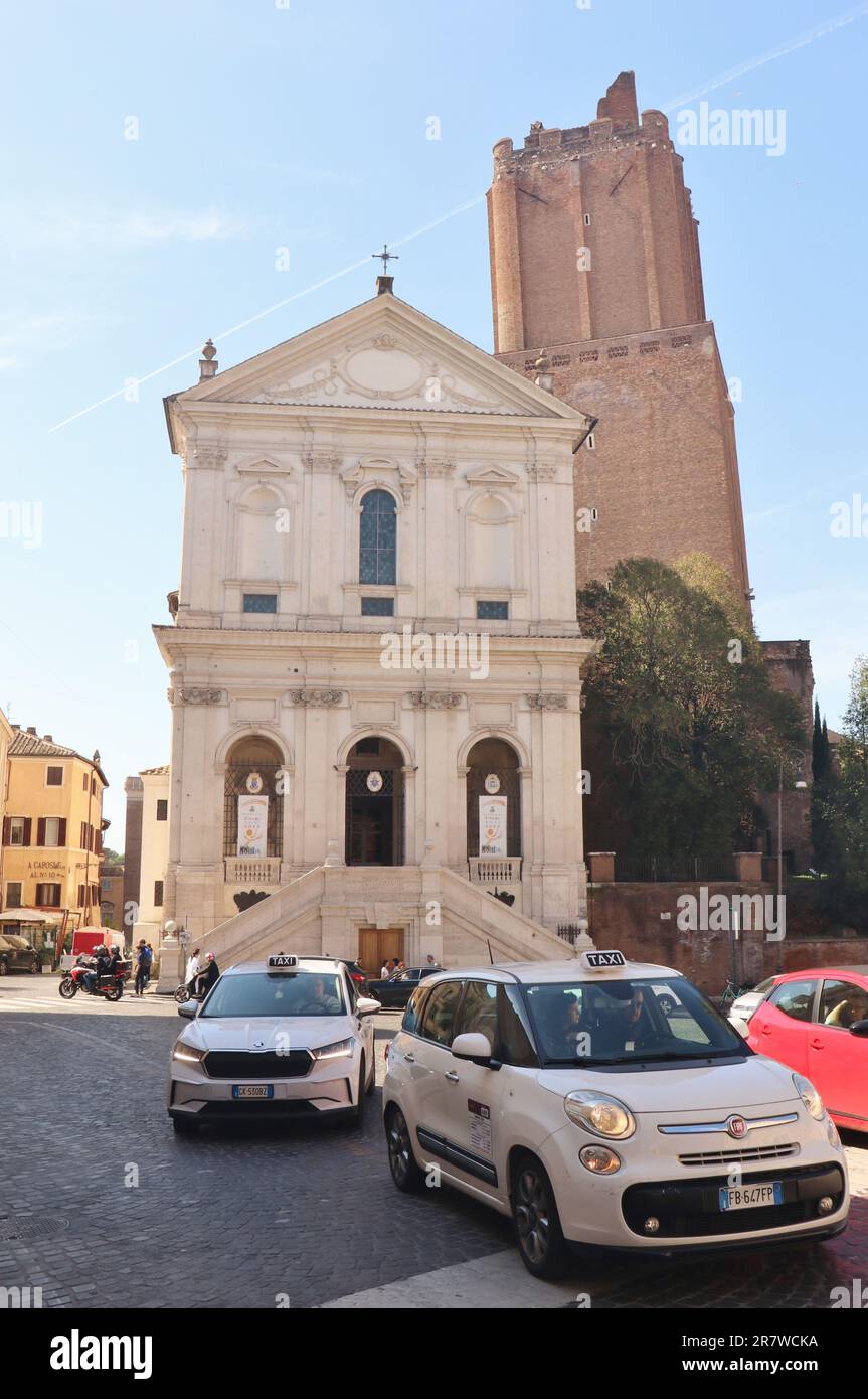 Taxifahrt auf der Straße vor der Kirche Santa Caterina a Magnanapoli und dem Torre delle Milizie im Stadtzentrum von Rom, Italien - 22 2023. April Stockfoto