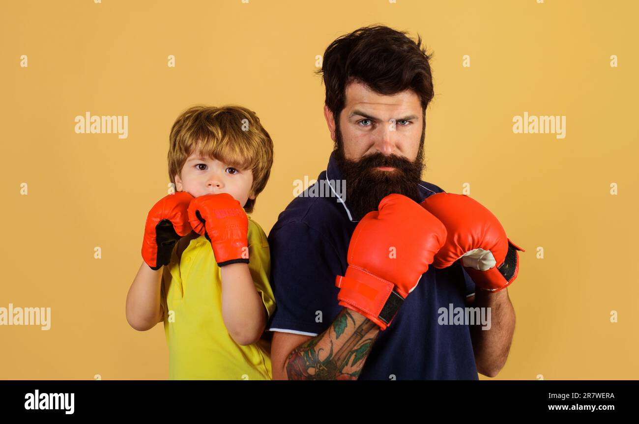 Kleiner Sportler mit Trainer beim Boxtraining. Kleiner Junge mit Boxtrainer, bereit zum Sparring. Kind und Trainer in Boxhandschuhen. Boxtrainer Stockfoto
