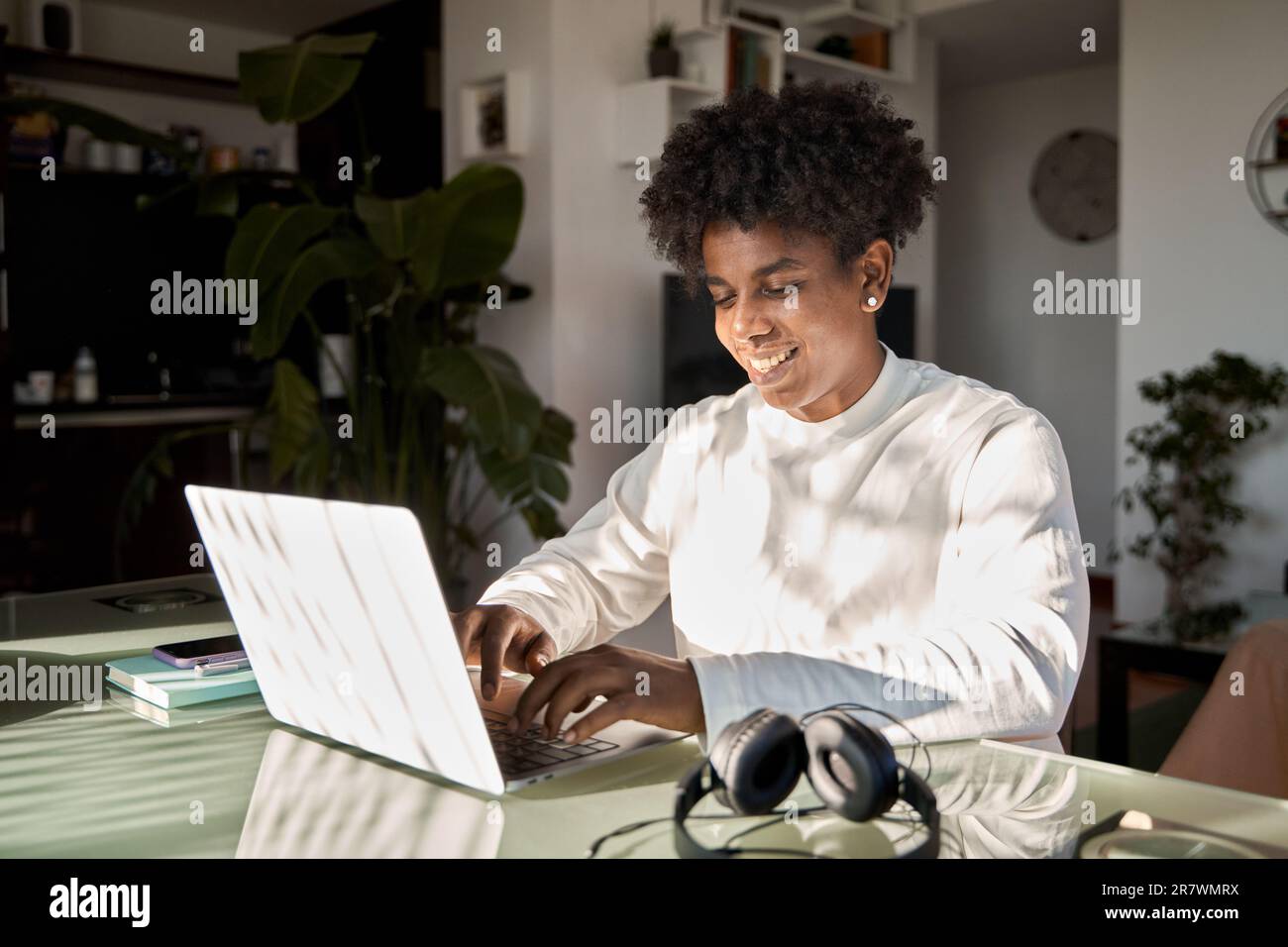 Afroamerikanischer Schüler der Generation z, der zu Hause E-learning mit Notebooks nutzt. Stockfoto