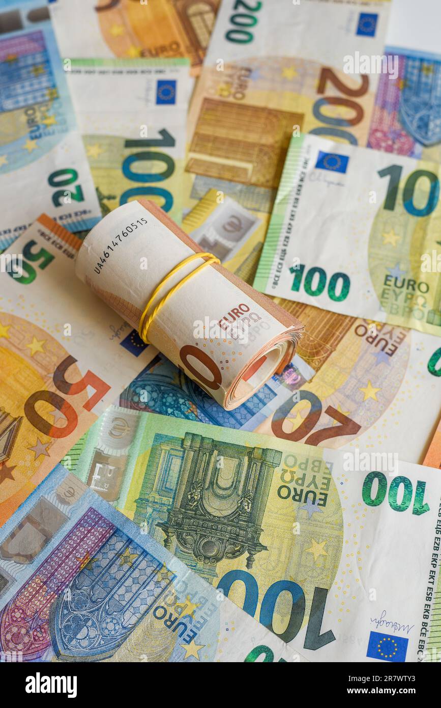 Dieses Bild zeigt einen Stapel Euro-Banknoten, von denen einer aufgerollt und ein anderer teilweise aufgerollt ist Stockfoto
