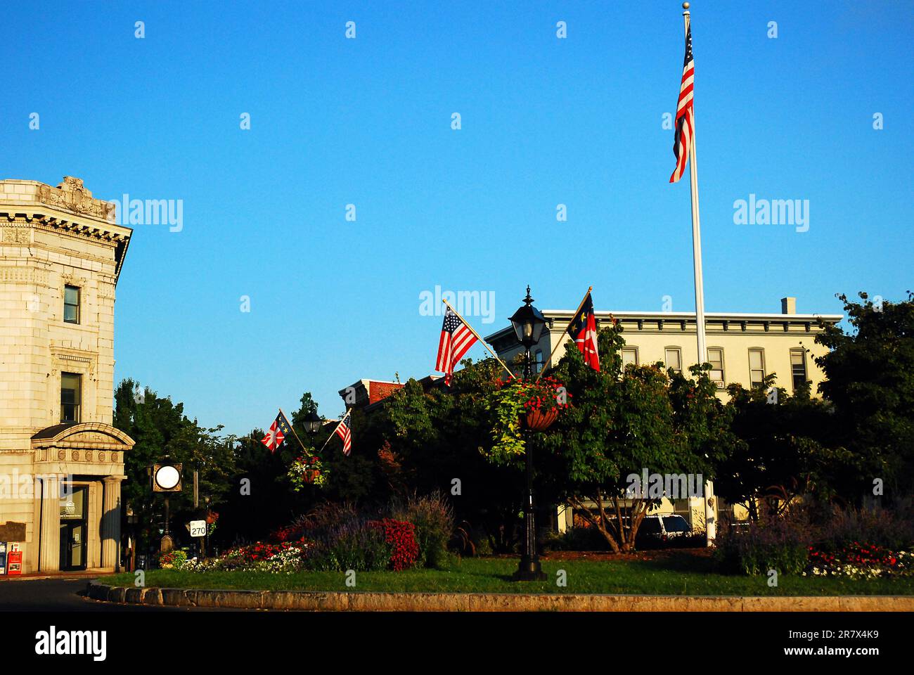 Am Lincoln Square, einem Park im Herzen von Gettysburg, Pennsylvania, steht eine amerikanische Flagge in einem Garten Stockfoto