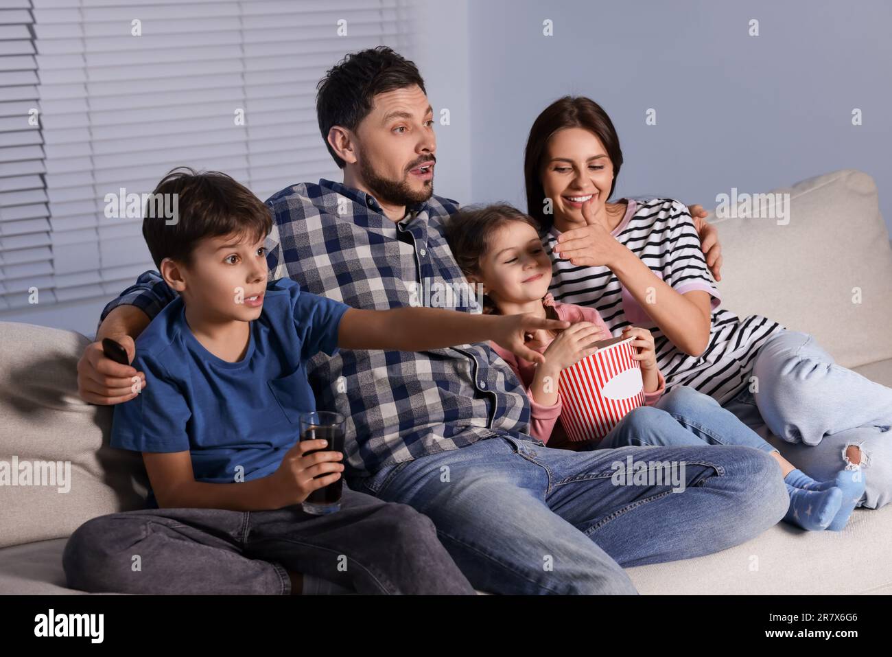 Familie schaut abends zu Hause fern Stockfoto
