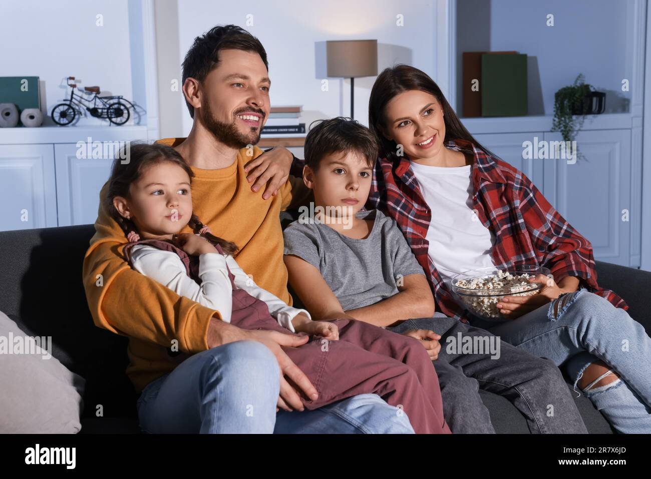 Familie schaut abends zu Hause fern Stockfoto