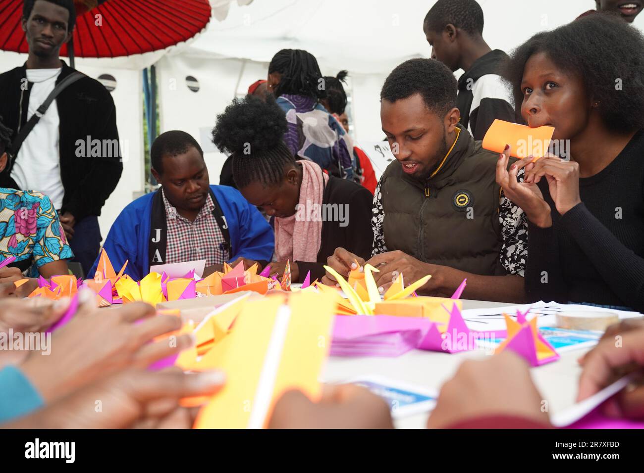 (230618) -- NAIROBI, 18. Juni 2023 (Xinhua) -- Menschen versuchen beim 8. Nairobi International Cultural Festival in Nairobi, Kenia, 17. Juni 2023, Papierfaltung auf dem Ausstellungsgelände Japans. Das achte internationale Kulturfestival von Nairobi fand am Samstag in der kenianischen Hauptstadt von Nairobi statt, als hochrangige Beamte und Diplomaten erneut dazu aufforderten, die kulturelle Vielfalt zu nutzen, um gegenseitiges Verständnis, Freundschaft und Respekt zu fördern. Das Kulturfestival wurde von den Nationalmuseen Kenias und ausländischen Missionen in Kenia veranstaltet und enthielt Musik, Tanz, Küche, Kunstwerke und Kleidung. (Xinhua/Han Xu) Stockfoto