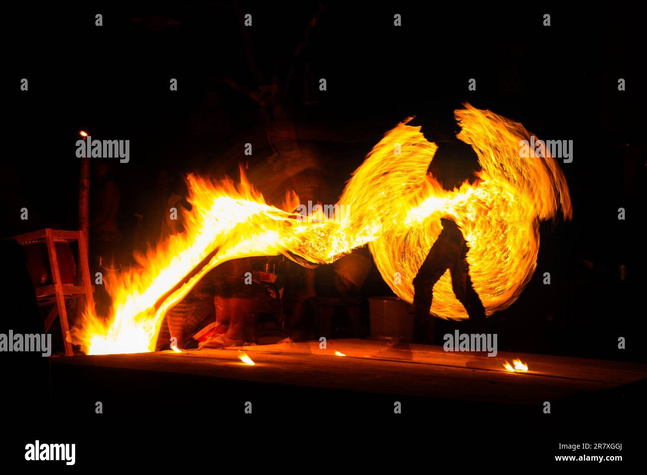 Verzögerte Exposition eines Feuerjongleurs, der am Strand auftritt und seine Fledermaus auf Koh Phi Phi Island, Thailand, ablässt Stockfoto