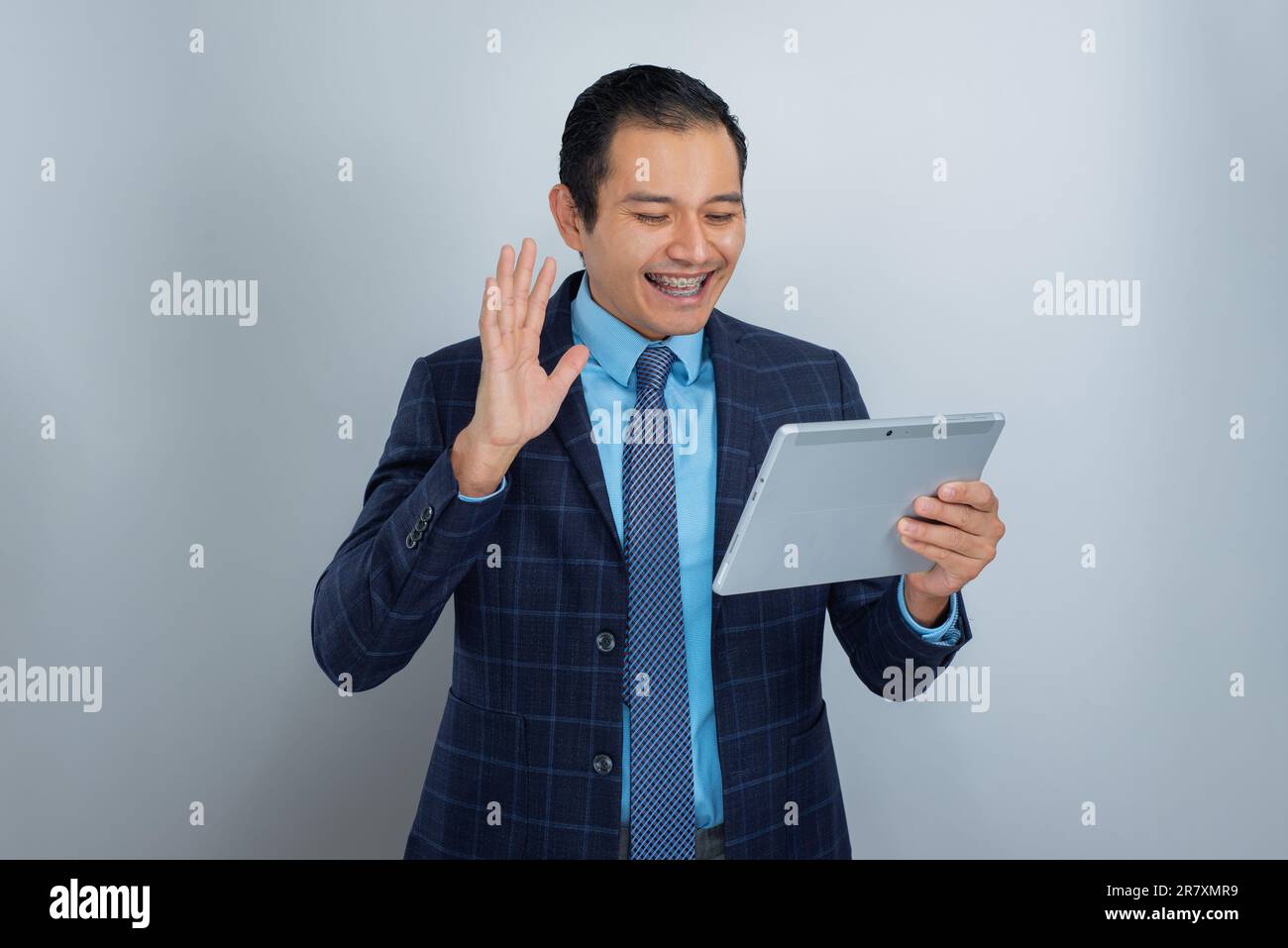 Ein junger hispanischer Mann mit brauner Haut begrüßt sich glücklich für einen Arbeitsvideo-Anruf Home Office, mexikanische Kleider Business Entrepreneur Style, eine Person Stockfoto