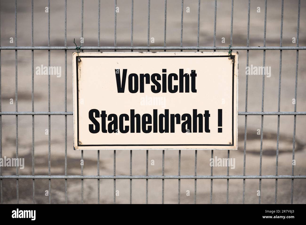 Kennzeichnung auf einem Zaun, Warnung vor Stacheldraht, im Hamburger Hafen. Einige Firmen schützen ihr eigenes Anwesen mit Stacheldraht. Bei wird eine Warnung angezeigt Stockfoto