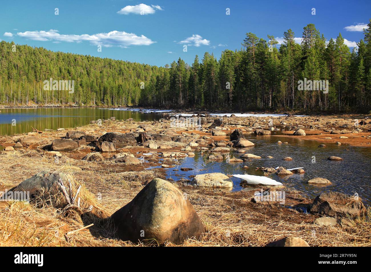 Wasserlandschaft im schwedischen lappland mit verbleibenden Eisschollen und Felsbrocken. Stockfoto