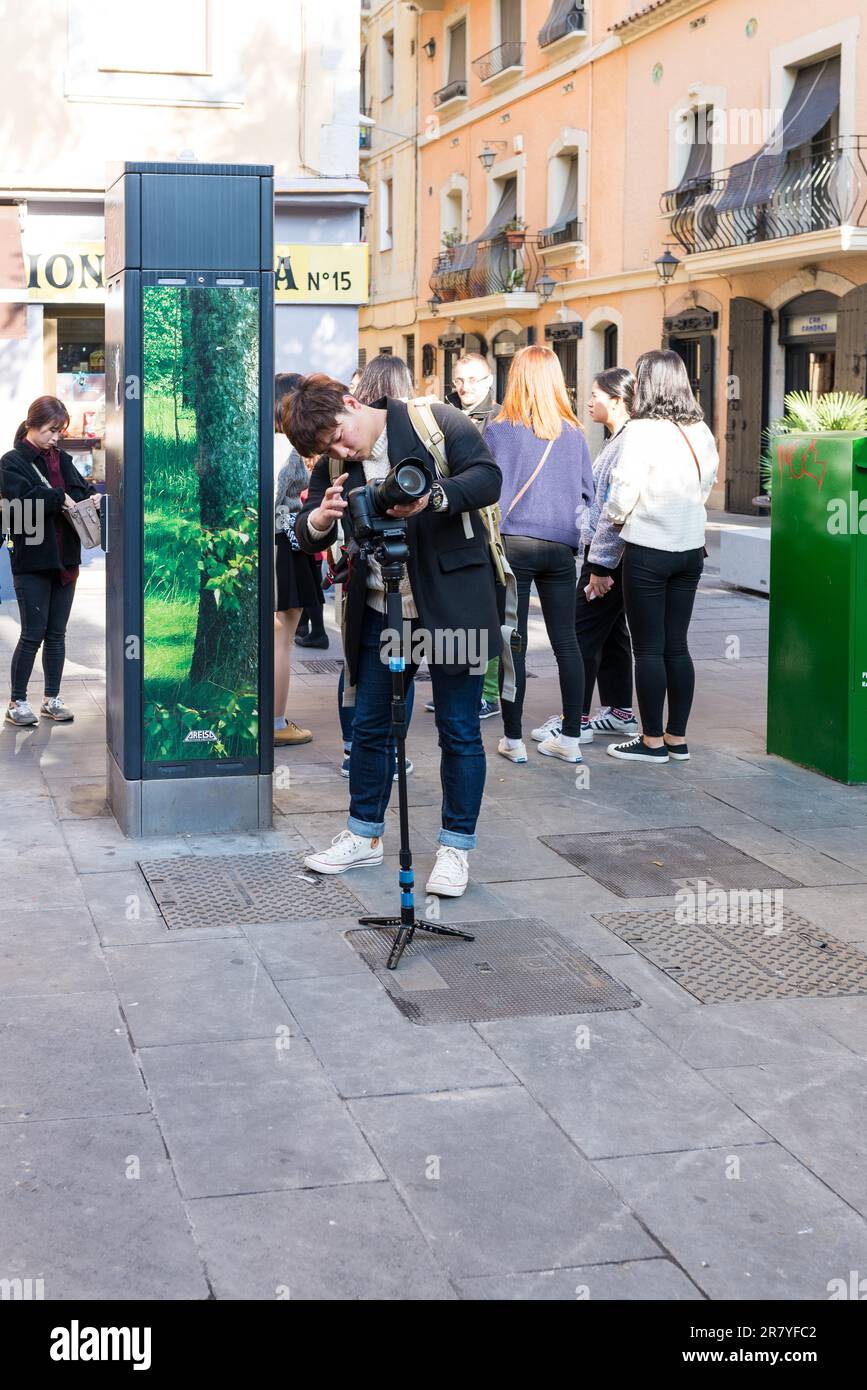 Ein asiatischer Fotograf macht Fotos von der Besichtigungstour im Barceloneta-Viertel von Barcelona. Barcelona ist eine der meistbesuchten Städte in Europa Stockfoto