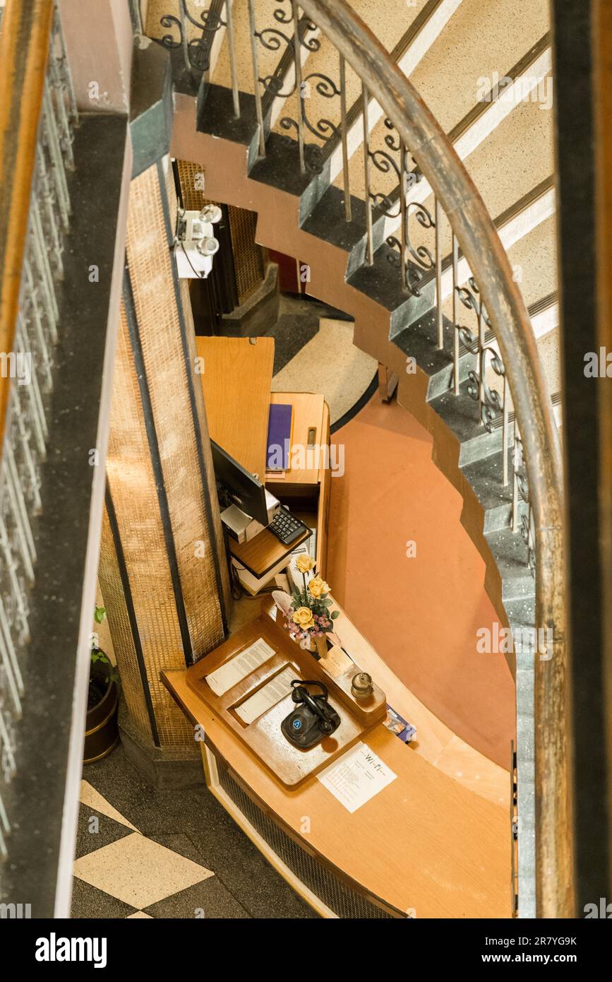 Blick nach unten auf die Lobby eines Hotels in Bangkok mit stilvoller Treppe und Handläufen Stockfoto