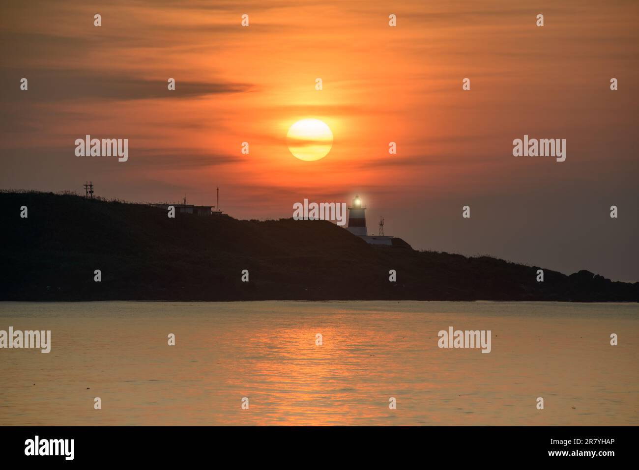 In der Dämmerung ist die Sonne über dem Leuchtturm. Das Fugui Cape Lighthouse in Shimen. Taiwan Stockfoto