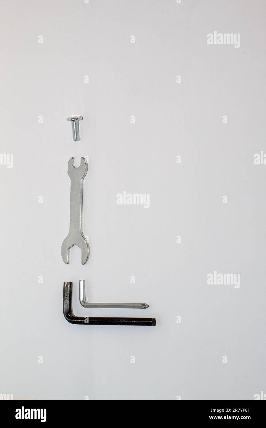 Die verschiedenen Werkzeuge zur Montage von Metall- und schwarzen Möbeln auf weißem Hintergrund Stockfoto