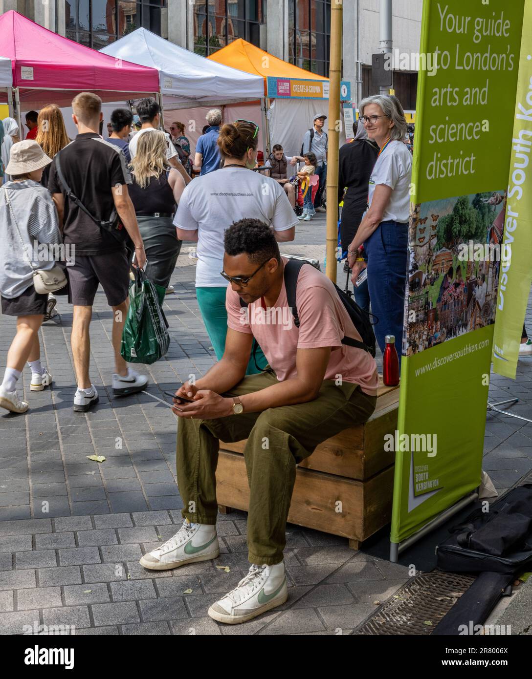 Das Great Exhibition Road Festival, Exhibition Road, South Kensington, ein jährliches Fest der Wissenschaft und Kunst; Mann, der sein Telefon überprüft Stockfoto