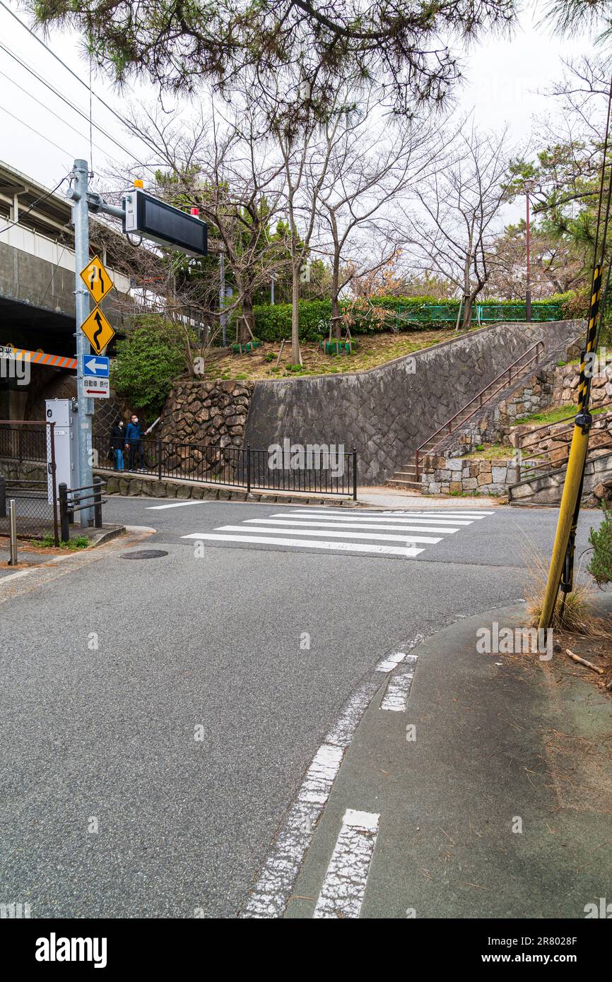 Fußgängerüberquerung über die Hauptstraße an einer Kreuzung mit der Kreuzung, die in der Mitte der Verbindungsstraße endet. Nishinomiya, Japan. Stockfoto