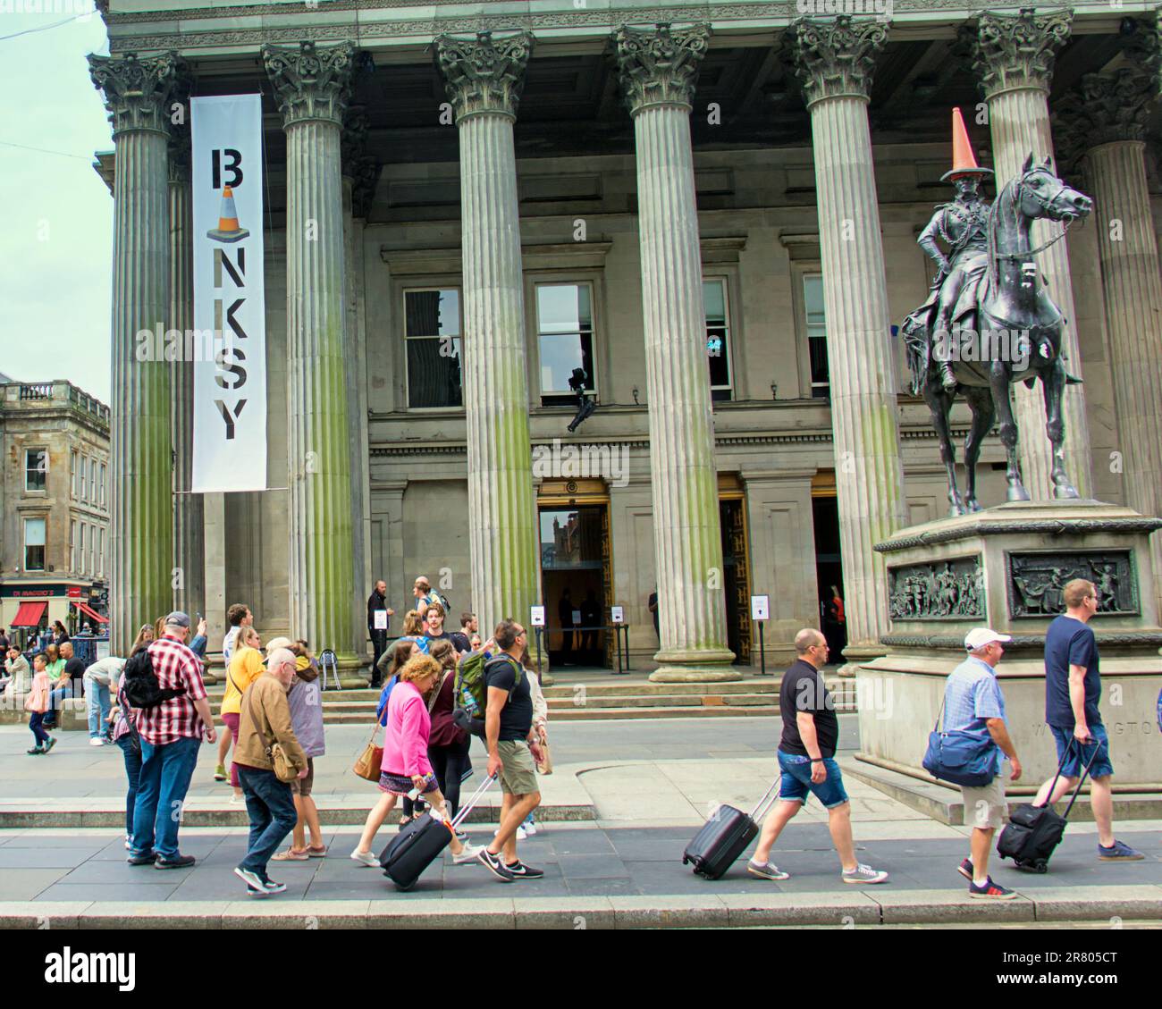 Glasgow, Schottland, Vereinigtes Königreich, 18. Juni 2023. Die Besucherzahlen in der CUT & RUN The Banksy-Ausstellung an der Statue des Herzog von Wellington mit dem Zapfenkopf vor dem GOMA, der Galerie für moderne Kunst, wurden heute eröffnet. Credit Gerard Ferry/Alamy Live News Stockfoto