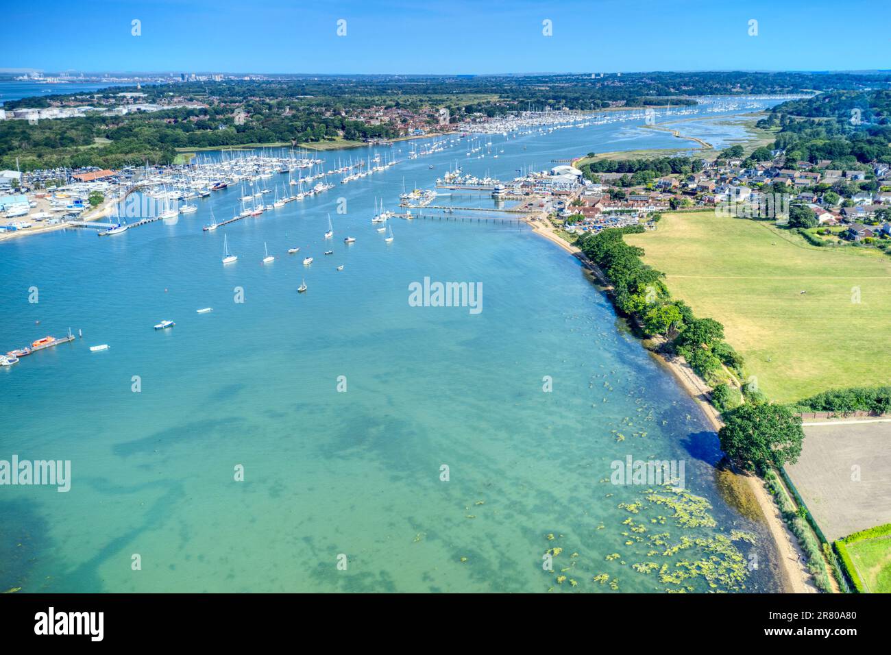 Segelboote und Yachten vor Anker und auf Pontons auf dem Fluss Hamble in Hampshire, England. Stockfoto