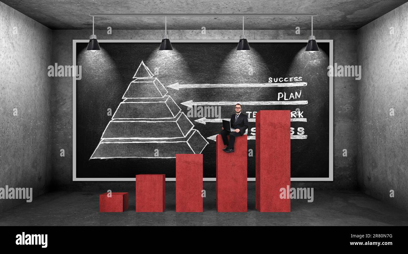 Ein Geschäftsmann, der auf der roten Karte sitzt und eine Geschäftspyramide an der Tafel zeichnet Stockfoto