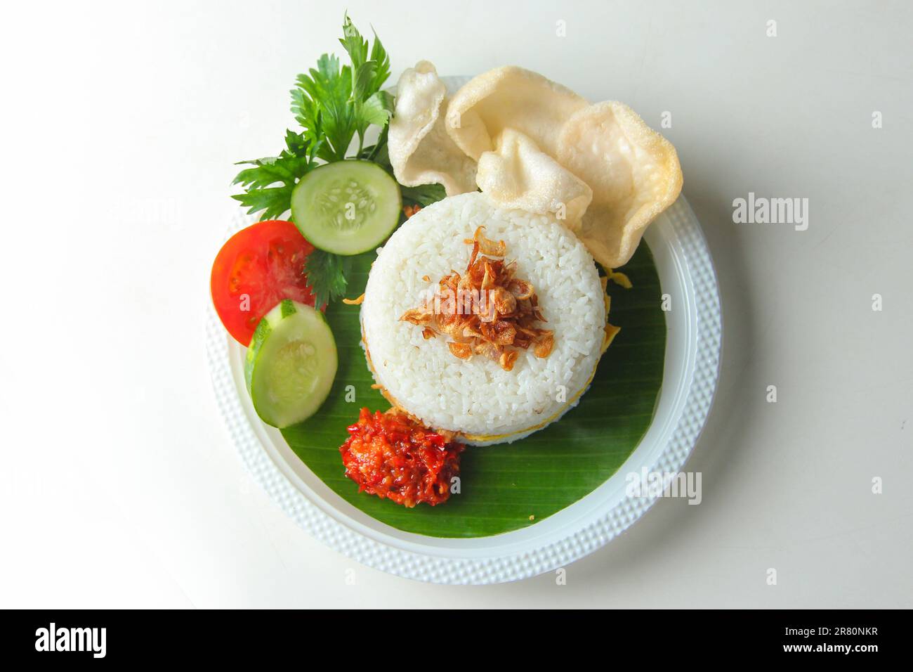 Indonesische Küche auf weißem Hintergrund. Reisburger mit scharfem Hühnchen, Eieromelette, Fisch, Sardelle, Rinderseide, Garnelen, Tomaten, Gurken, Sellerie Stockfoto