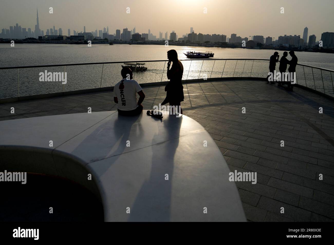 People stand on the observation deck of the Dubai Creek Harbour in Dubai, United Arab Emirates, Sunday, June 18, 2023, to view the city skyline with the world's tallest tower, the Burj Khalifa. (AP Photo/Kamran Jebreili) Stockfoto