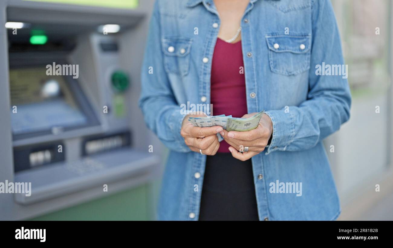 Junge, wunderschöne hispanische Frau, die chilenische Pesos-Banknoten bei der Kasse zählt Stockfoto