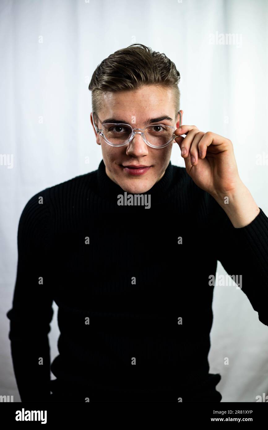 Ein junger Erwachsener, der eine Brille trägt, mit neugieriger Art Stockfoto