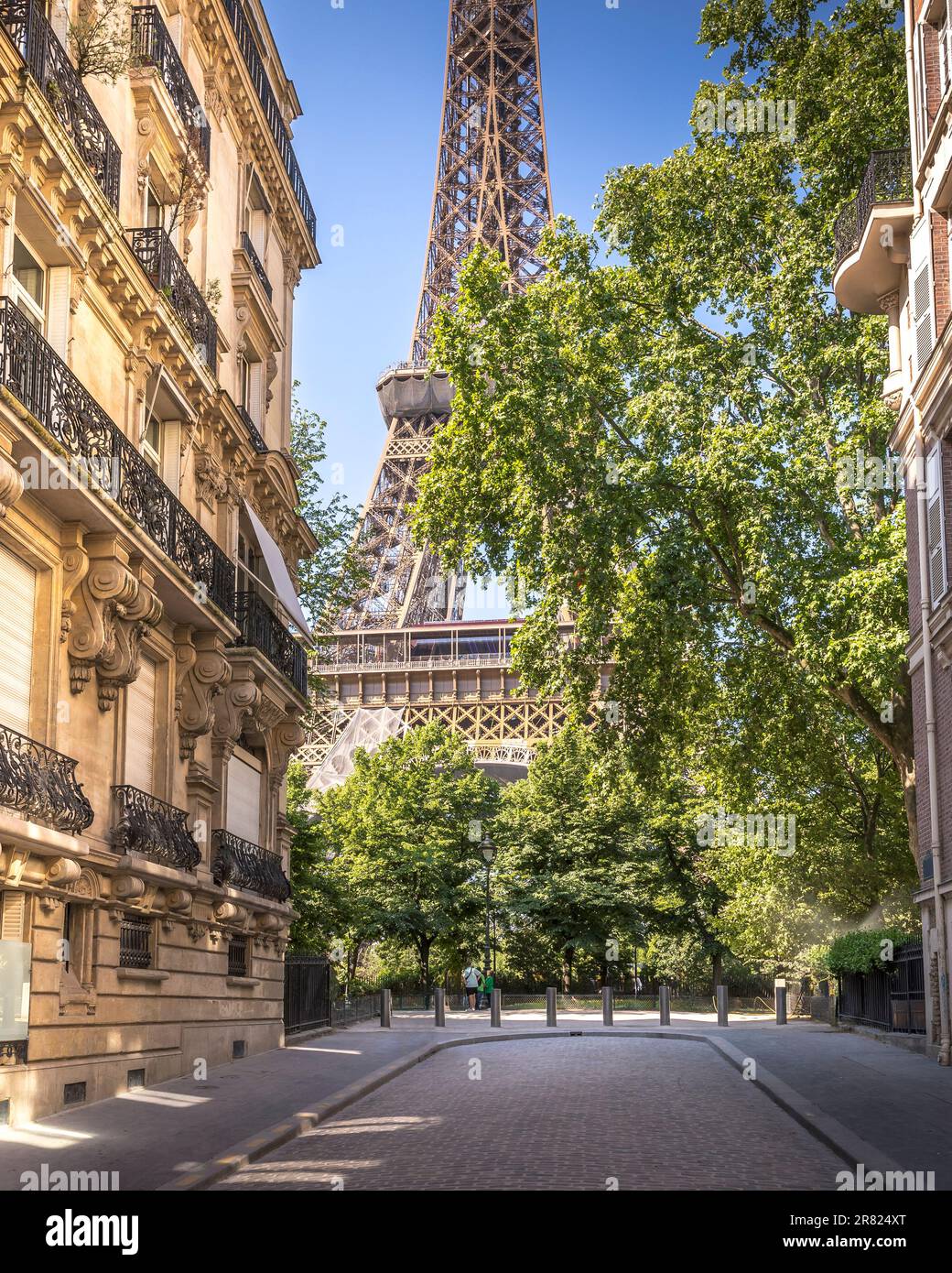 Paris, Frankreich - 5. Juni 2023: Wunderschöne Aussicht auf den Eiffelturm von einer Straße mit Haussmann-Gebäuden Stockfoto