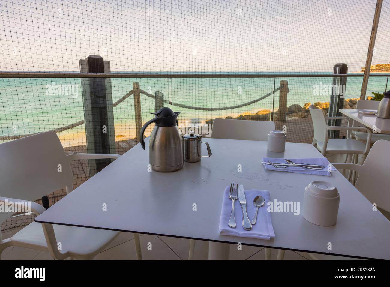 Nahansicht des Tisches mit Besteck zum Frühstück im Freiluftrestaurant mit Blick auf den Atlantischen Ozean. Aruba. Stockfoto