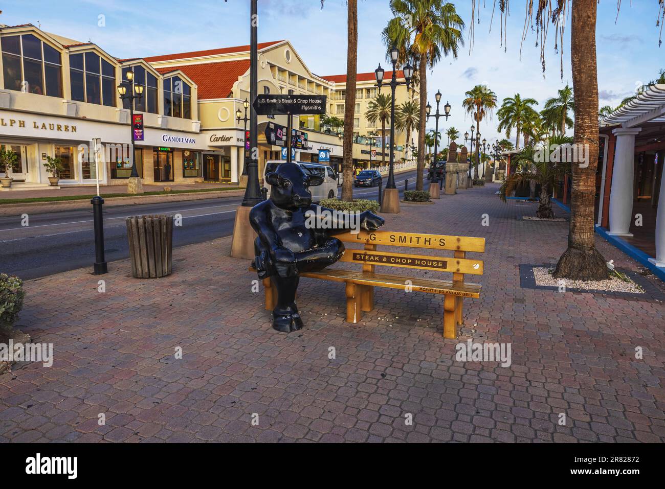 Wunderschöne Aussicht auf die Hauptstraße in Oranjestad mit niedlicher Statue des schwarzen Nilpferdes auf der Werbebank für LG.Smith Steak und Kotelett. Oranjestad. Stockfoto