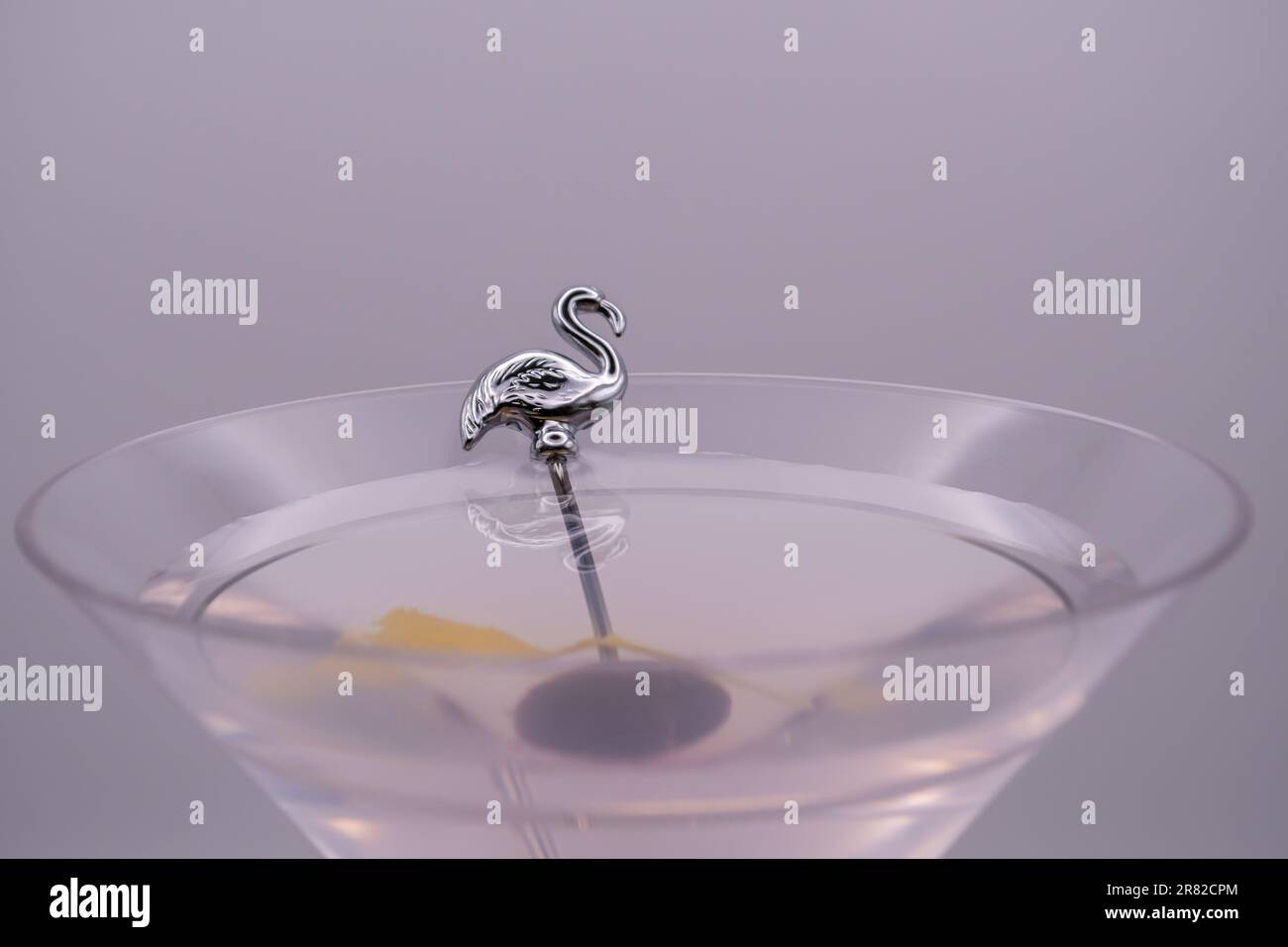 Die Kunst der Mixologie: Makroaufnahme eines isolierten Martini mit Garnierung, Nahaufnahme eines martini mit Flamingo-Pflücken und Garnieren Stockfoto